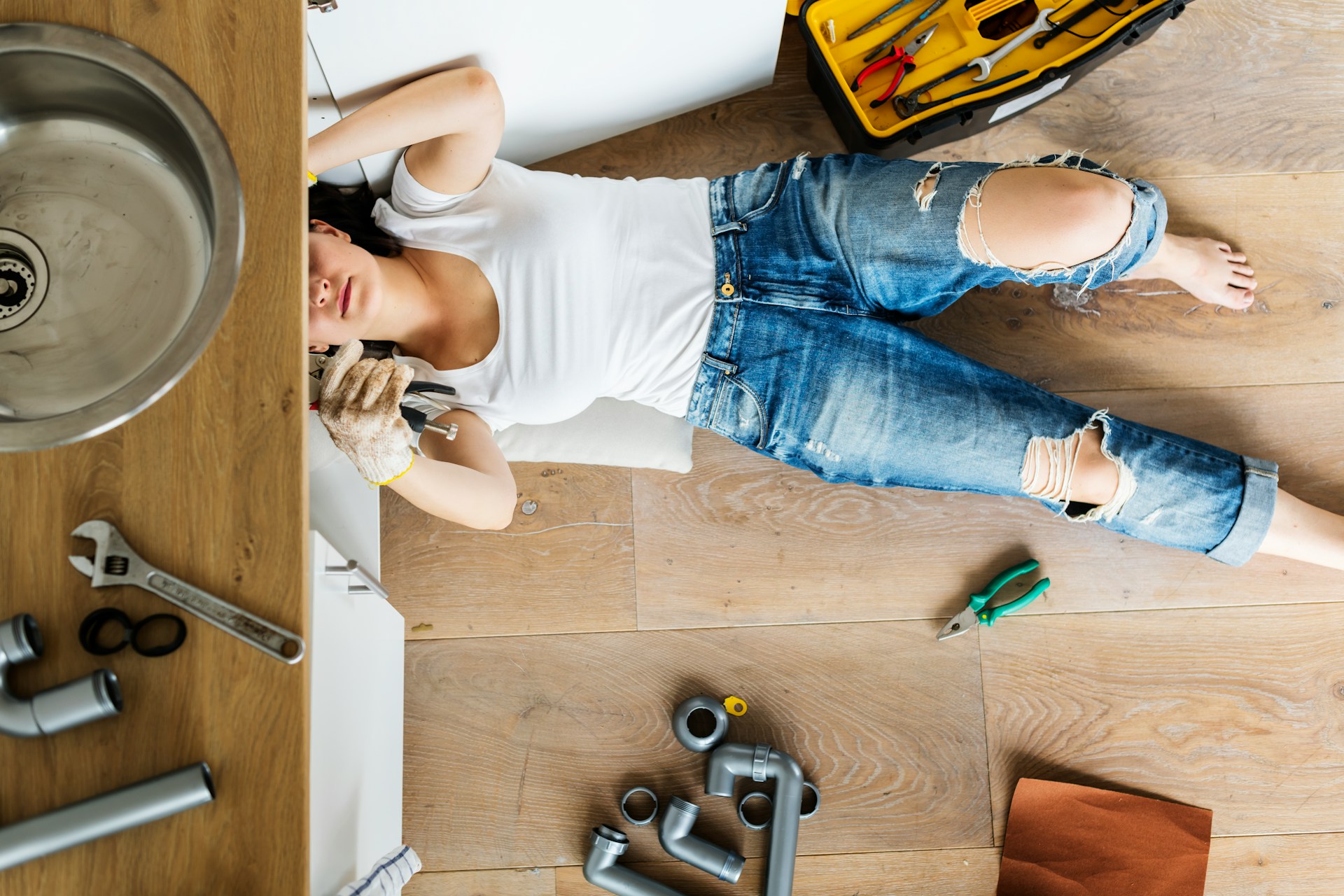 a woman trying to fix plumbing